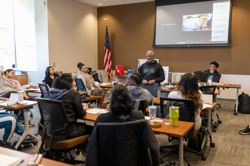 An older black man (Raymond Jetson) leads a leadership discussion with a Urban Leadership Development Intiative Cohort of students.